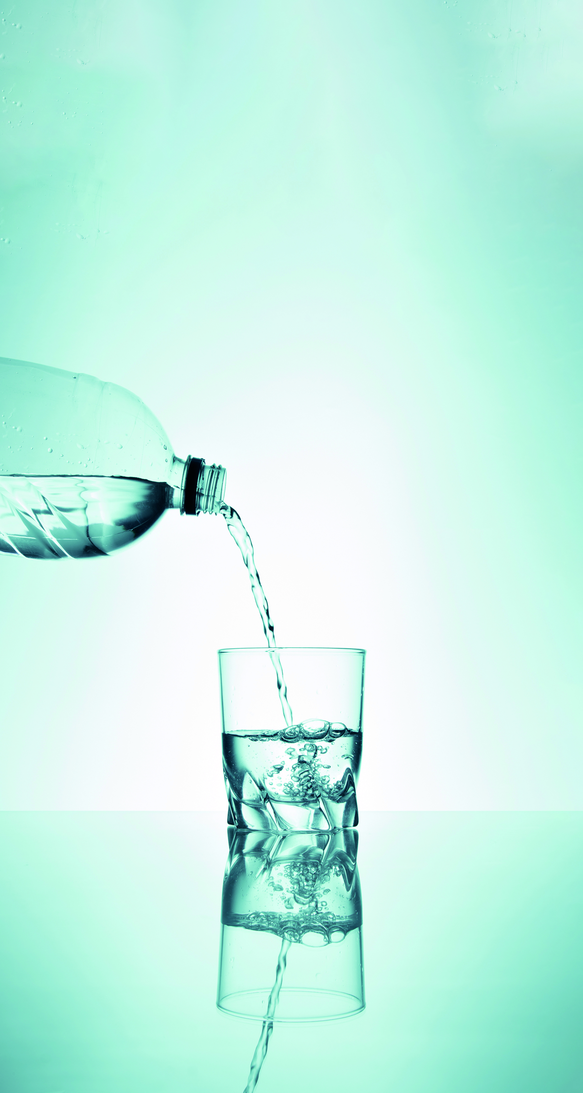 Wasser wird aus einer Plastikflasche in ein Glas gegossen